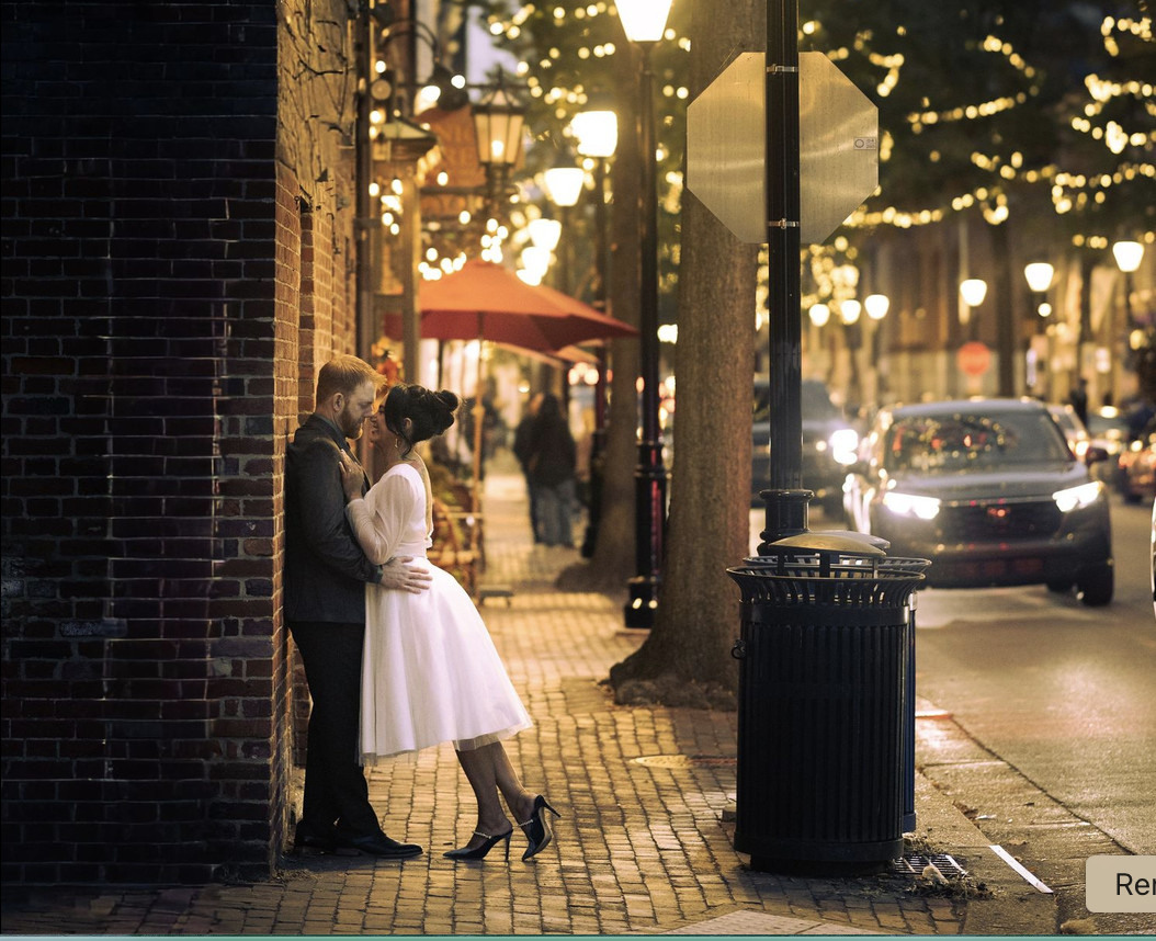 Couple embracing on a lantern-lit brick street at dusk