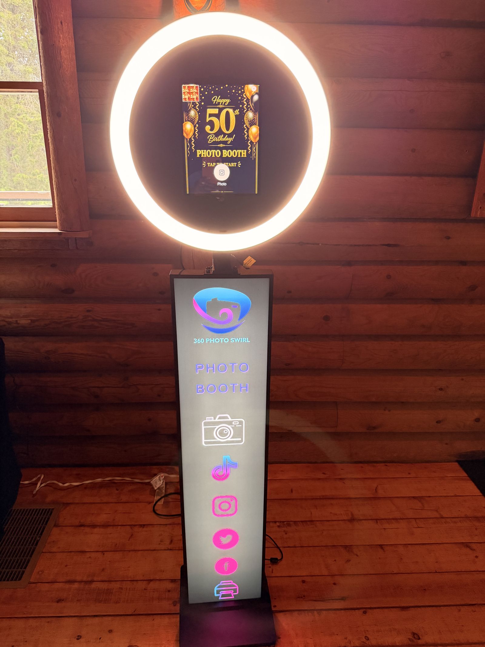 Standard Tower photo booth glowing warmly at a 50th birthday party in a log cabin venue