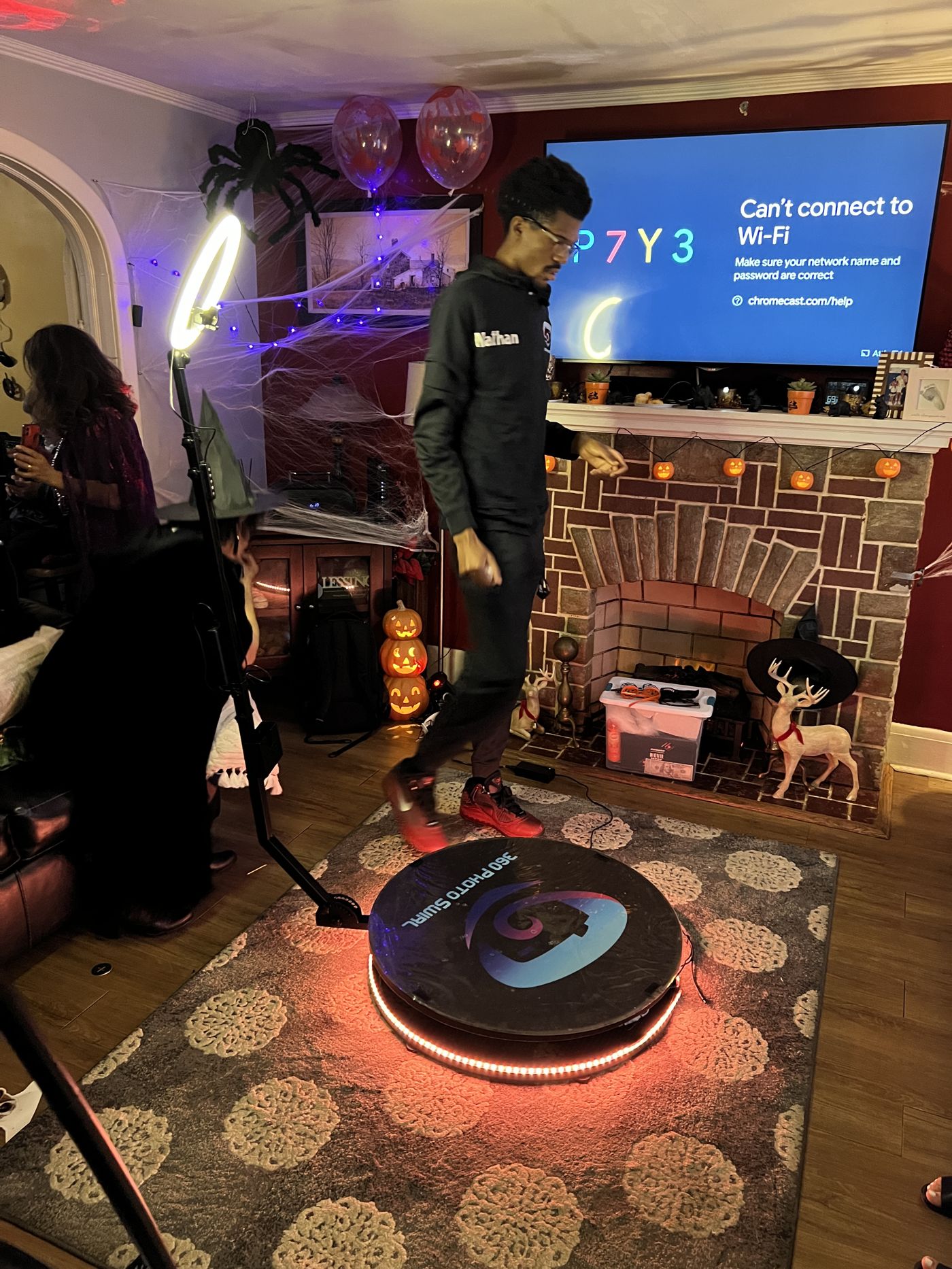Guest mid-spin on the 360 platform at a Halloween party with red ring light