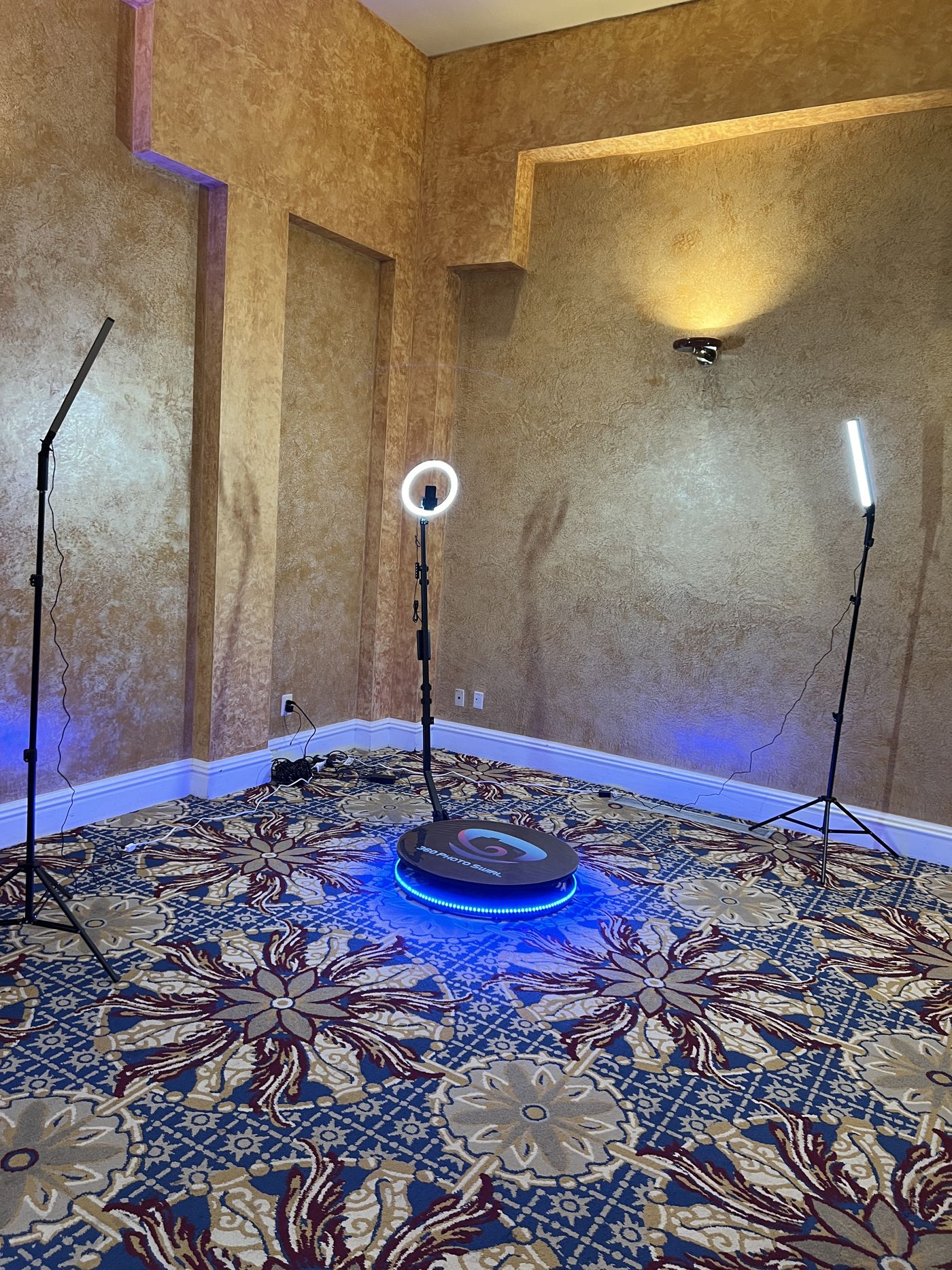 360 platform with white ring light in an ornate gold-toned banquet room